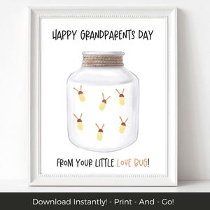 Pode incluir: Uma impressão emoldurada com o texto "HAPPY GRANDPARENTS DAY" e "FROM YOUR LITTLE LOVE BUG!". A imagem apresenta um frasco transparente com uma tampa enrolada em corda, contendo vaga-lumes amarelos. A impressão está em uma moldura branca.