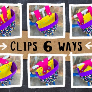 May include: Six images of bicycle baskets, each with a yellow interior, a purple rim, and a patterned exterior with colorful hearts. The baskets are attached to a bicycle handlebar with pink straps. The text "CLIPS 6 WAYS" is displayed on a brown background.