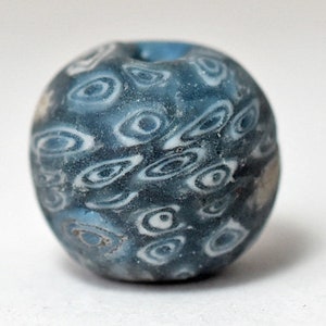 以下が含まれることがあります： 白い渦巻き模様の青いガラスビーズ。ビーズは丸く、表面が滑らかです。