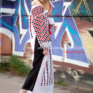 May include: A white linen dress with red and black polka dots embroidery. The dress has a long sleeve and a loose fit. The model is wearing black heeled sandals. The dress is photographed in front of a graffiti wall. The text "etsy.com/shop/HelenCloth Real Photo" is visible in the image.