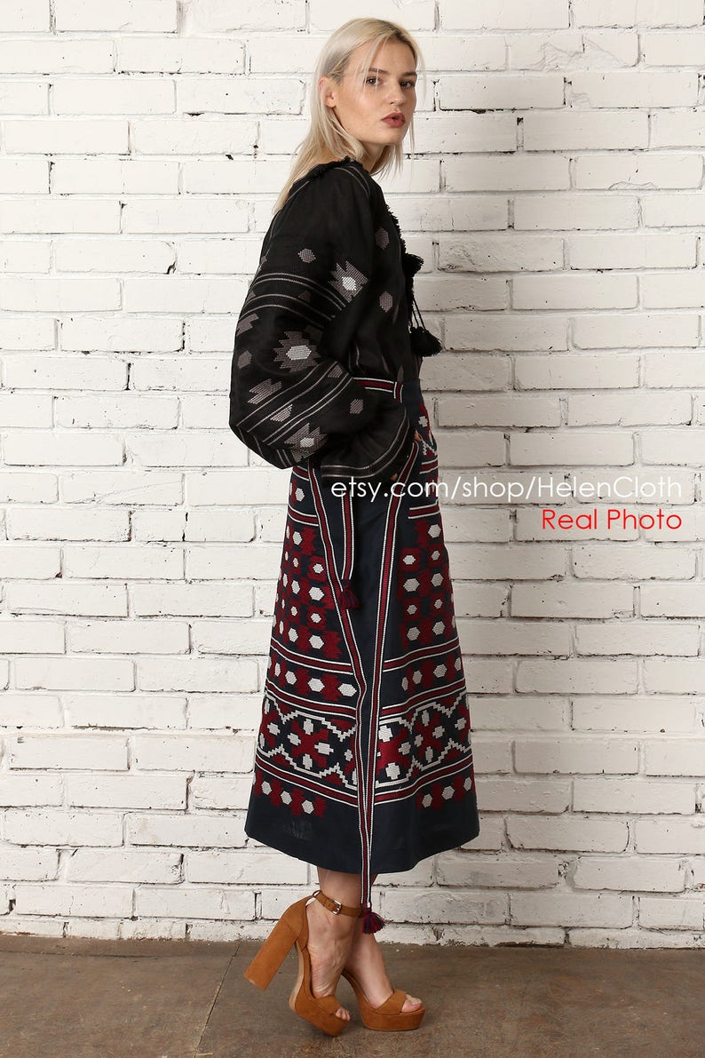 May include: A black embroidered linen blouse with a long, dark blue skirt featuring a geometric pattern. The skirt has a red and white design. The model is wearing brown heeled sandals. etsy.com/shop/HelenCloth Real Photo