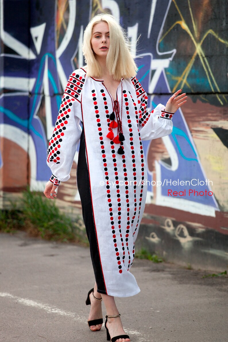 May include: White linen dress with black and red embroidered polka dots. The dress has a long, flowing silhouette and a V-neckline. The model is wearing black heeled sandals. etsy.com/shop/HelenCloth Real Photo