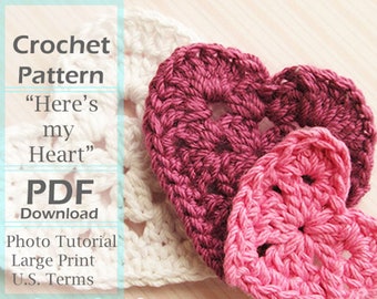 May include: Crochet pattern PDF download for a heart-shaped design. The pattern includes a photo tutorial and is printed in large print using U.S. terms. The image shows three crocheted hearts in pink and burgundy.