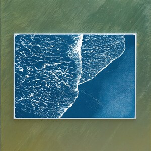 Puede incluir: Una impresi&oacute;n enmarcada de una imagen abstracta azul y blanca de olas del oc&eacute;ano rompiendo en una playa.