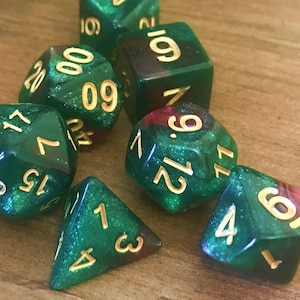 May include: A set of six green and red dice with gold numbers. The dice are made of a translucent material and have a sparkly finish.