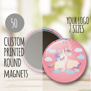May include: 50 custom printed round magnets featuring a pink background with two unicorns, one with rainbow wings, on a cloud with a blue sky and white clouds. The text "YOUR LOGO 7 SIZES" is in the upper right corner of the image.