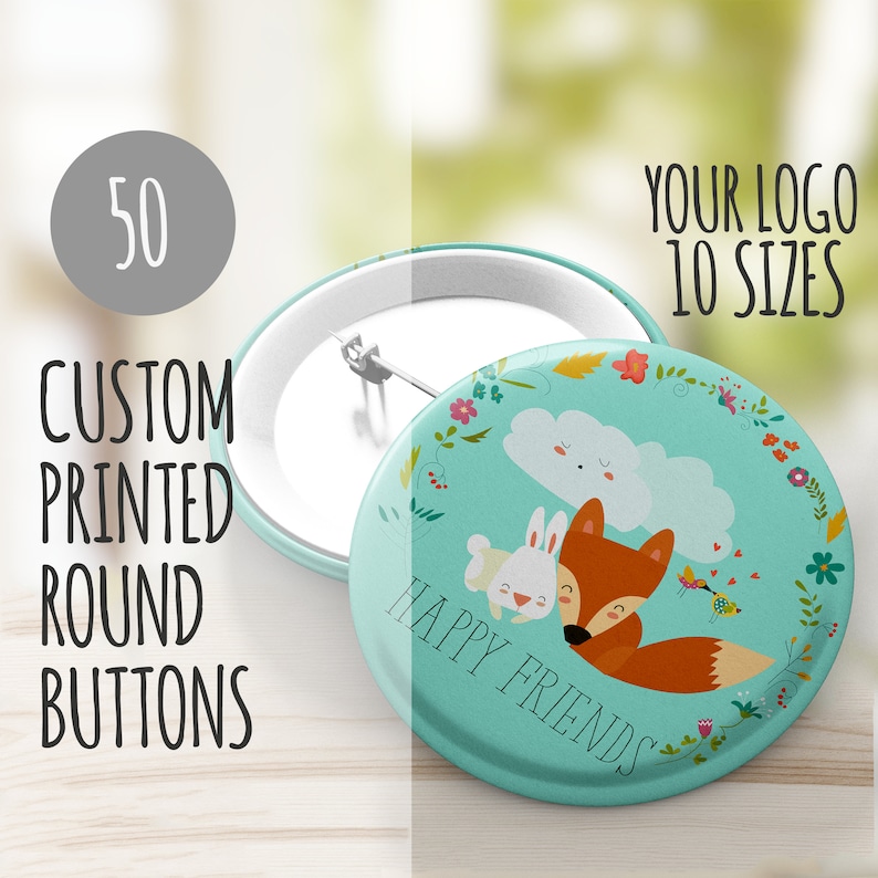 May include: A turquoise round button with a fox and rabbit illustration. The button has a white cloud with a smiling face and the text "Happy Friends" in a white circle. The button is surrounded by a floral wreath.