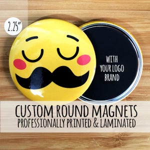 May include: A 2.25 inch round custom magnet with a yellow background and a cartoon face with a mustache. The magnet is open to reveal a black surface with the text "WITH YOUR LOGO BRAND".