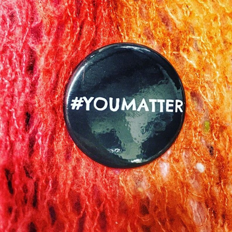 May include: A black button with white text that reads "#YOU MATTER" on a red and orange background.