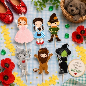 May include: A collection of whimsical Wizard of Oz themed party decorations. Includes character cutouts of Dorothy, the Scarecrow, the Tin Man, the Cowardly Lion, the Wicked Witch, and Glinda. Also features ruby red slippers, a basket with a dog, and a sign that says "We're off to see the Wizard!"