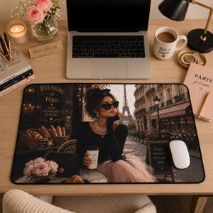 May include: A decorative mousepad featuring a Parisian scene with a woman in sunglasses, the Eiffel Tower, and a cafe. The mousepad has a black border and includes the text "BOULANGERIE de PARIS".