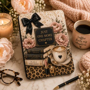 May include: A rectangular e-reader case featuring a floral pattern with pink flowers, a black satin bow, and a black square plaque with the text "JUST ONE MORE CHAPTER". The design includes illustrations of stacked books, a coffee cup, and a lipstick.