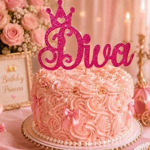 May include: A pink frosted cake with a decorative 'Diva' cake topper and a crown design. The cake is decorated with pink frosting swirls, bows, and pearls. A framed sign reads 'Birthday Princess'.