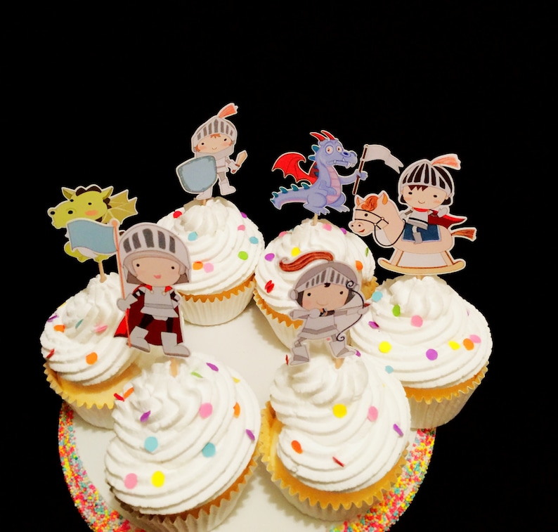 May include: A set of six cupcakes decorated with colorful sprinkles and topped with various character toppers, including a knight, a dragon, and a unicorn. The cupcakes are arranged on a white plate with a colorful sprinkle border.
