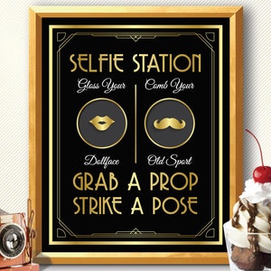 May include: A black and gold sign with the text "SELFIE STATION" in gold letters. The sign has two sections, one with a gold lipstick and the text "Glass Your Dollface" and the other with a gold mustache and the text "Comb Your Old Sport". The sign also has the text "GRAB A PROP STRIKE A POSE" in gold letters.