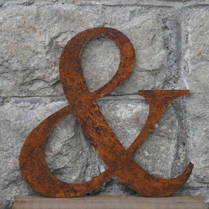 May include: A rusty metal ampersand symbol, a decorative accent for a home or office.
