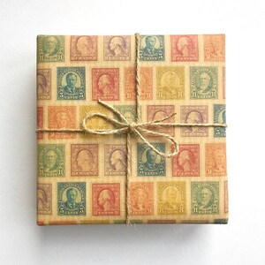 K&ouml;nnte beinhalten: Braunes Geschenkpapier mit einem sich wiederholenden Muster aus Vintage-Briefmarken mit Portr&auml;ts historischer Pers&ouml;nlichkeiten. Die Briefmarken sind in Rot-, Blau-, Gr&uuml;n- und Gelbt&ouml;nen gehalten. Das Papier ist mit Schnur gebunden.