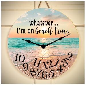 May include: A round beach-themed clock with a sunset and ocean scene. The clock face has gold glitter and black numbers. The text "whatever... I'm on beach time" is printed on the clock face.
