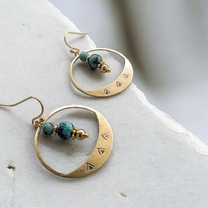 Op de afbeelding: Gouden creolen met turquoise kralen en een driehoekspatroon op de ring.