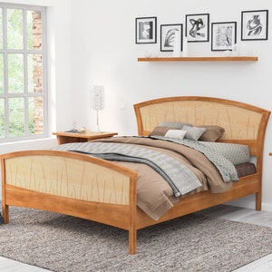 This is a handmade wooden bed with a curved headboard and footboard.  The headboard and footboard are inlaid with curved wood pieces that look like river rushes.  The bed is made with cherry and curly maple wood.
