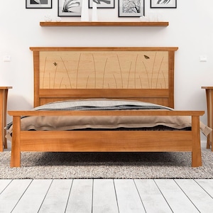 This is a handmade wood bed frame shown in solid cherry and curly maple.  The curly maple headboard is inlaid with butterflies and curved contrasting wood pieces that look like river rushes.  The bed is shown with matching nightstands.