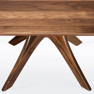 Rectangular coffee table handmade in solid walnut wood. This table has a pedestal base with four curved legs connected at the center. The look of the table is midcentury modern, Danish modern and Scandinavian.  Available in a variety of sizes.