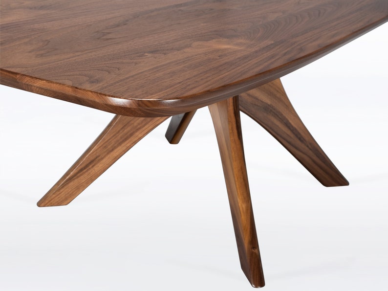 Rectangular coffee table handmade in solid walnut wood. This table has a pedestal base with four curved legs connected at the center. The look of the table is midcentury modern, Danish modern and Scandinavian.  Available in a variety of sizes.