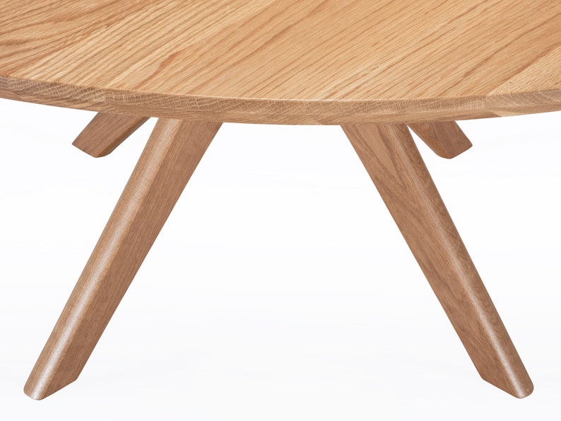 Round dining table handmade in solid white oak wood. This table has a pedestal base with four curved legs connected at the center. The look of the table is midcentury modern, Danish modern and Scandinavian.  The table available in a variety of sizes.