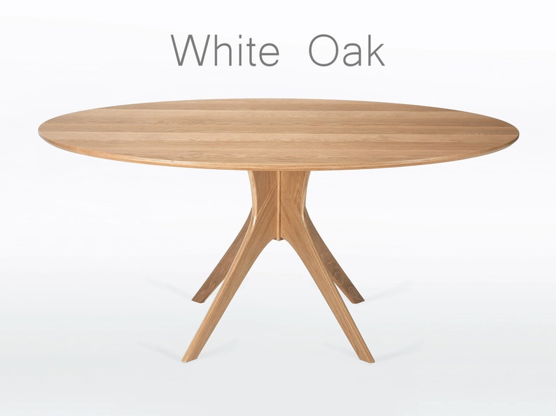 Oval dining table handmade in solid white oak wood. This table has a pedestal base with four curved legs connected at the center. The look of the table is midcentury modern, Danish modern and Scandinavian.  The table available in a variety of sizes.