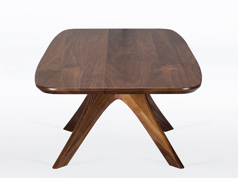 Rectangular coffee table handmade in solid walnut wood. This table has a pedestal base with four curved legs connected at the center. The look of the table is midcentury modern, Danish modern and Scandinavian.  Available in a variety of sizes.