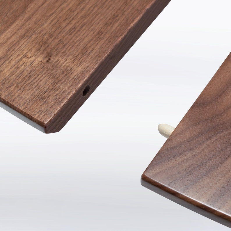 A modern round extendable dining table hand crafted in solid walnut wood.