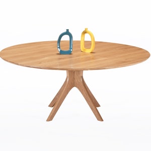 Round dining table handmade in solid white oak wood. This table has a pedestal base with four curved legs connected at the center. The look of the table is midcentury modern, Danish modern and Scandinavian.  The table available in a variety of sizes.