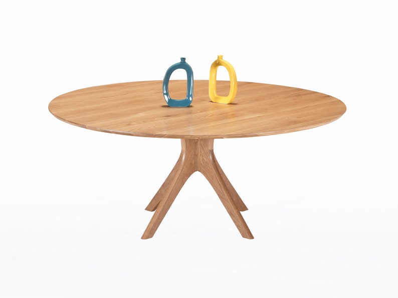 Round dining table handmade in solid white oak wood. This table has a pedestal base with four curved legs connected at the center. The look of the table is midcentury modern, Danish modern and Scandinavian.  The table available in a variety of sizes.