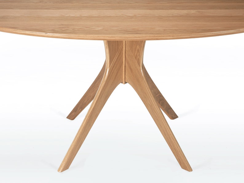 Oval dining table handmade in solid white oak wood. This table has a pedestal base with four curved legs connected at the center. The look of the table is midcentury modern, Danish modern and Scandinavian.  The table available in a variety of sizes.