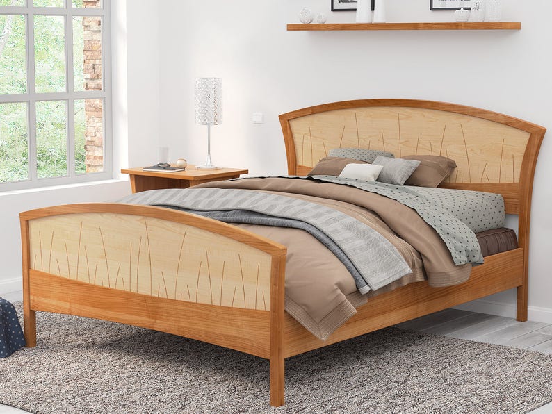 This is a handmade wood bed frame. The bed frame is shown in solid cherry and curly maple.  The curly maple headboard is inlaid with curved contrasting wood pieces that look like river rushes.  The bed is shown with matching nightstands.