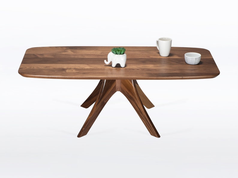 Rectangular coffee table handmade in solid walnut wood. This table has a pedestal base with four curved legs connected at the center. The look of the table is midcentury modern, Danish modern and Scandinavian.  Available in a variety of sizes.