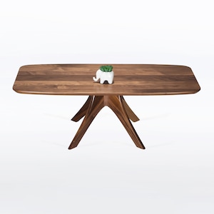 Rectangular coffee table handmade in solid walnut wood. This table has a pedestal base with four curved legs connected at the center. The look of the table is midcentury modern, Danish modern and Scandinavian.  Available in a variety of sizes.