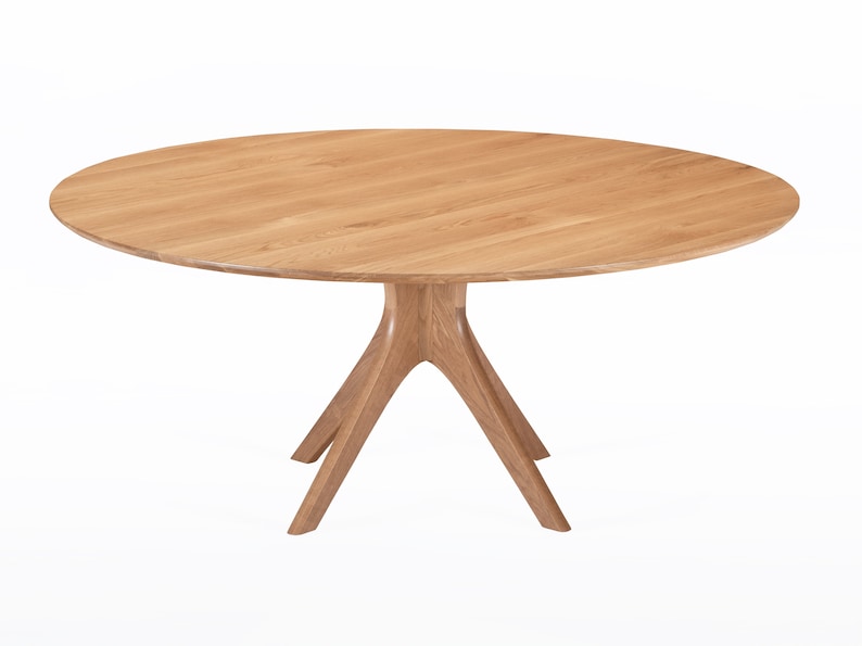 Round dining table handmade in solid white oak wood. This table has a pedestal base with four curved legs connected at the center. The look of the table is midcentury modern, Danish modern and Scandinavian.  The table available in a variety of sizes.