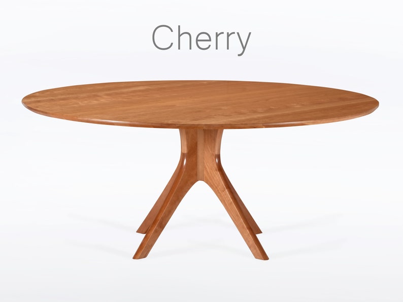 Round dining table handmade in solid cherry wood. This table has a pedestal base with four curved legs connected at the center. The look of the table is midcentury modern, Danish modern and Scandinavian.  The table available in a variety of sizes.