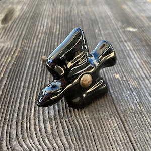 May include: Black ceramic bird-shaped cabinet knob with a gold-toned screw.