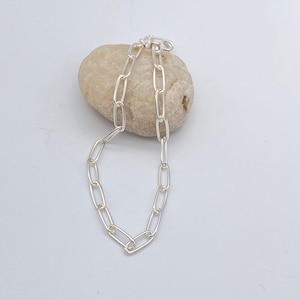 May include: A silver chain necklace with a simple oval link design.
