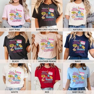 K&ouml;nnte beinhalten: Ein Set aus 10 T-Shirts in verschiedenen Farben mit einem grafischen Design mit dem Text "Special Education It's a Good Day to Be Different!" Das Design enth&auml;lt einen Globus, einen Bleistift, einen Pinsel, ein Buch und ein Namensschild mit der Aufschrift "Hello!"