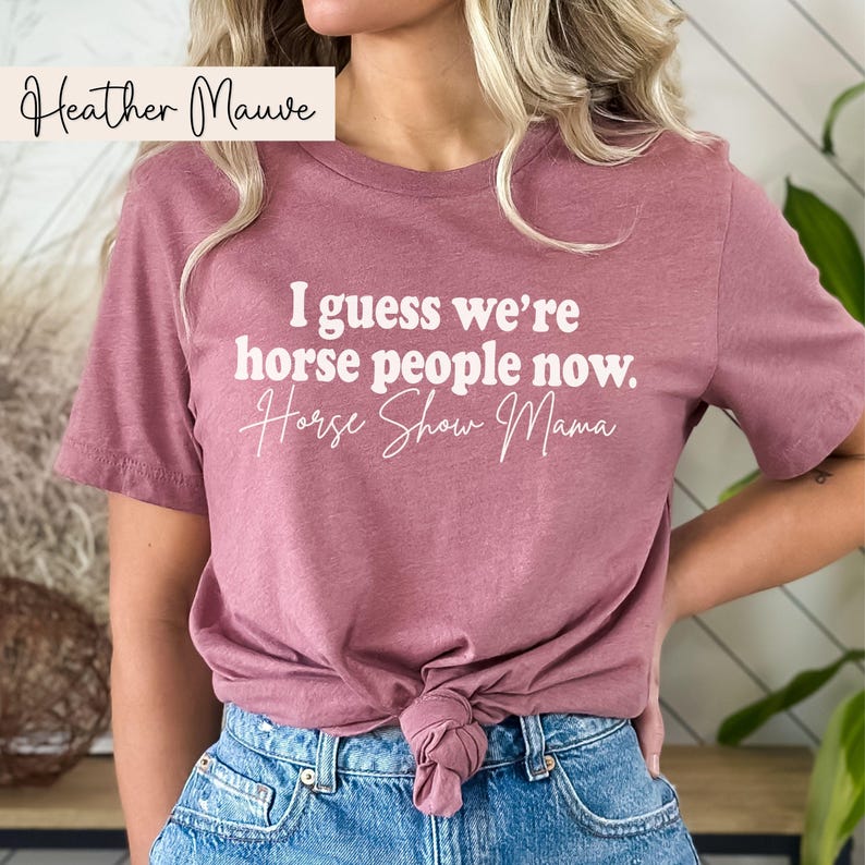 Peut inclure: Un t-shirt mauve clair avec le texte "I guess we're horse people now. Horse Show Mama" en blanc.