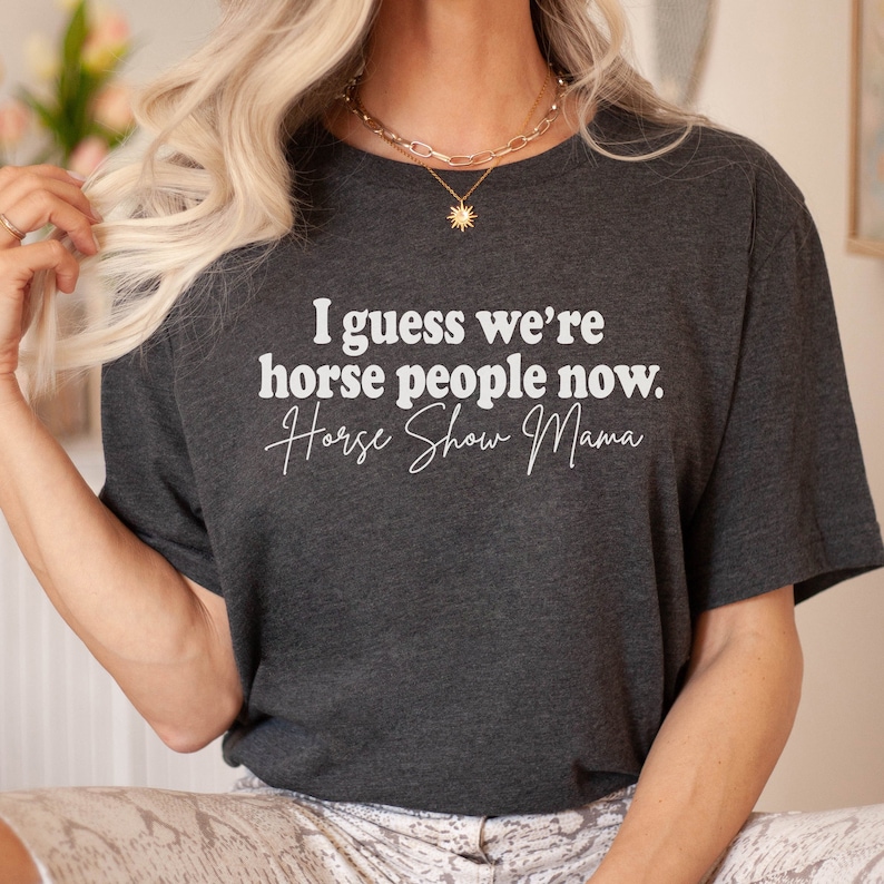 Peut inclure: Un t-shirt gris fonc&eacute; avec le texte "I guess we're horse people now. Horse Show Mama" en blanc.
