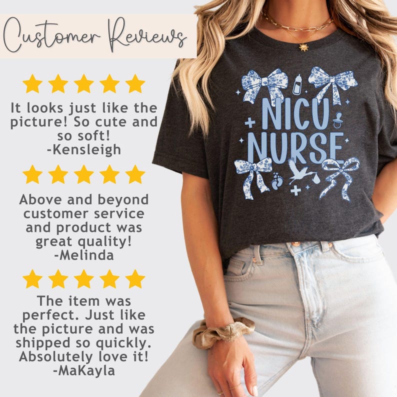 May include: A dark gray t-shirt with a blue and white design featuring bows, baby footprints, a pacifier, and a stork. The text "NICU NURSE" is printed in blue on the shirt.