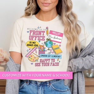 May include: A white t-shirt with a pink and blue design featuring school supplies, a globe, and the text "Welcome to the Front Office in my admin era", "Hello! My name is Mrs. Anderson", "ABCD", "Sonoran Sky Elementary", and "Happy to see your face!" The text "Customize with your name & school!" is at the bottom of the image.