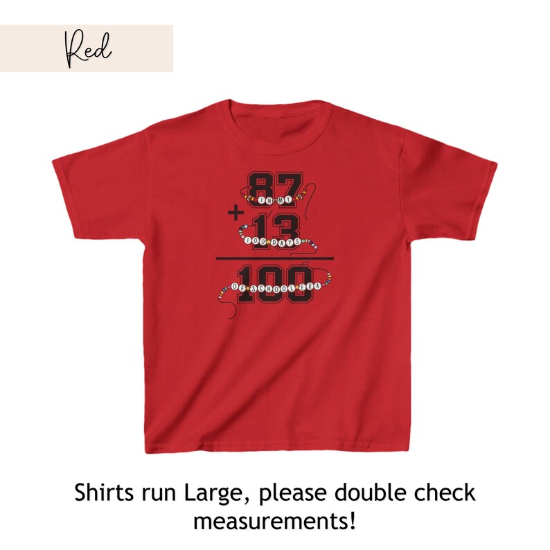 May include: Red t-shirt with a graphic of a math equation: 87 + 13 = 100. The numbers are surrounded by colorful beads. The text "Shirts run Large, please double check measurements!" is below the graphic.