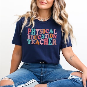May include: A navy blue t-shirt with the text "PHYSICAL EDUCATION TEACHER" in rainbow colors.