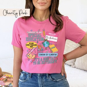 K&ouml;nnte beinhalten: Pinkes T-Shirt mit einem grafischen Design, das eine Willkommensnachricht zur sonderp&auml;dagogischen F&ouml;rderung, ein Namensschild mit der Aufschrift "Hallo! Mein Name ist Frau Anderson" und verschiedene Schulmaterialien zeigt. Der Text am unteren Rand des Designs lautet "Sonoran Sky Elementary. Es ist ein guter Tag, um anders zu sein!"