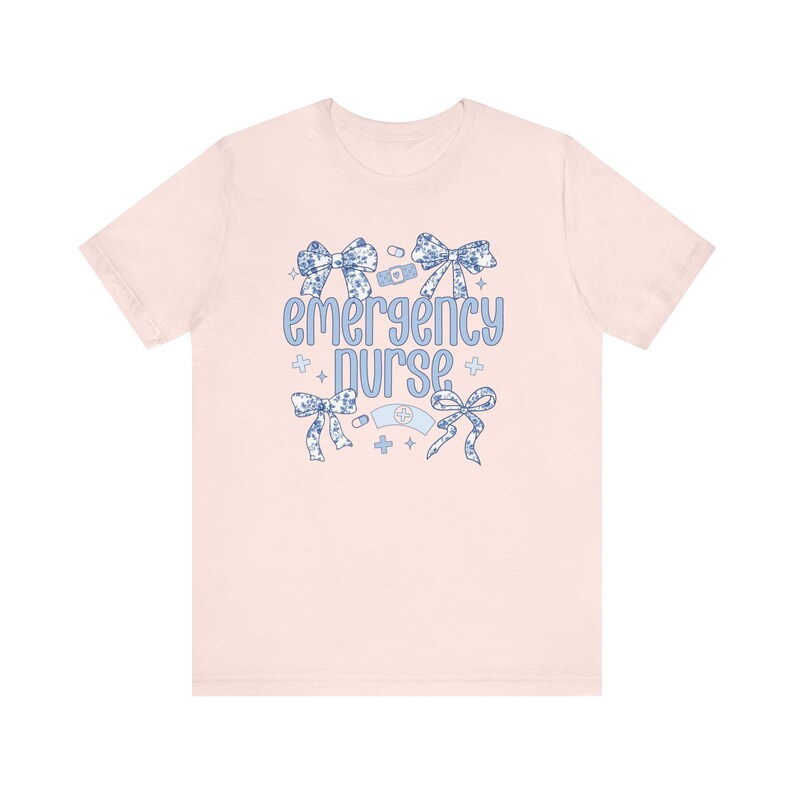 May include: Pink t-shirt with a blue and white floral design and the text "emergency nurse".